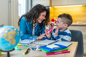 Young autistic boy laughing with instructor