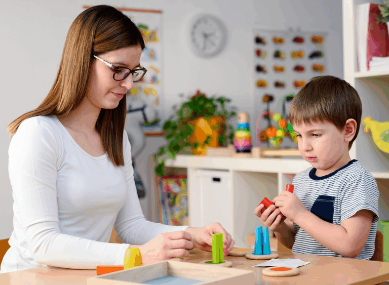 Adult looking at a child playing with an educational didactic toy