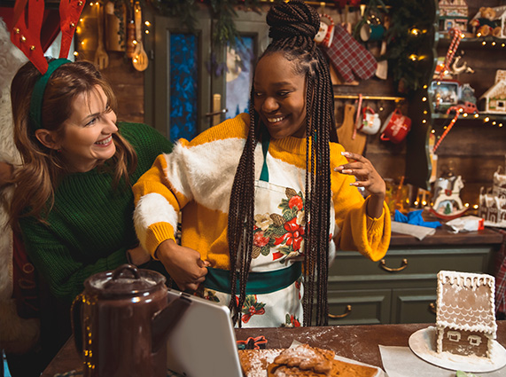 Young women dancing and making gingerbread houses.