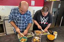 Life Program: Male adults cooking.